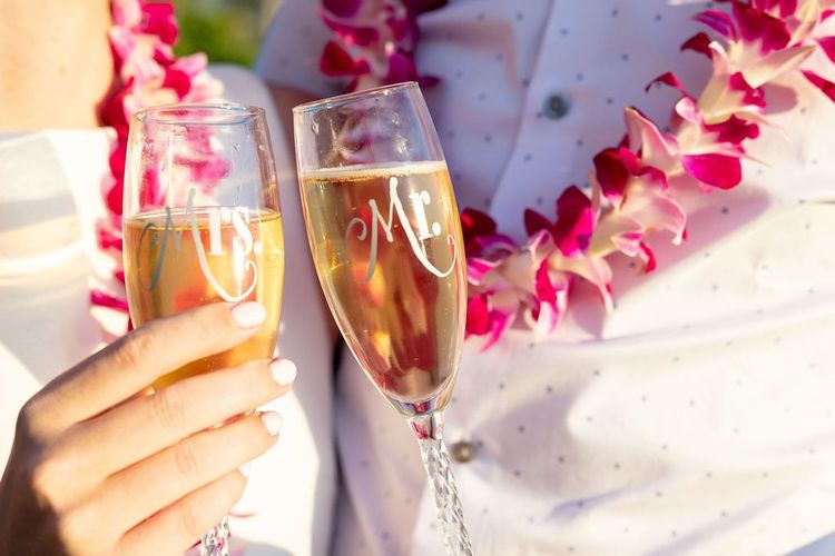 Traditional Hawaiian pink flower lei with champagne flutes for wedding celebration