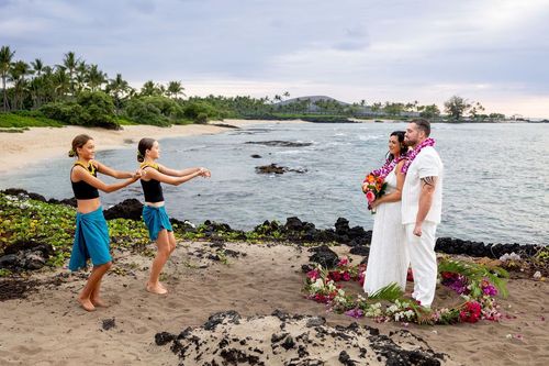 Celebrating on rocky Hawaii beach coastline with tropical greenery and ocean views