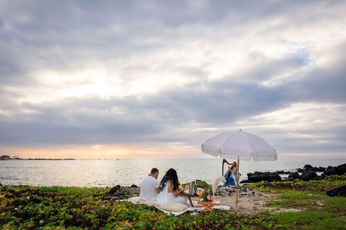 Beach picnic scene at sunset with dramatic cloudy sky and romantic ambiance in Hawaii