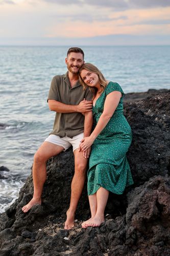 A man and woman on a rocky beach in Hawaii