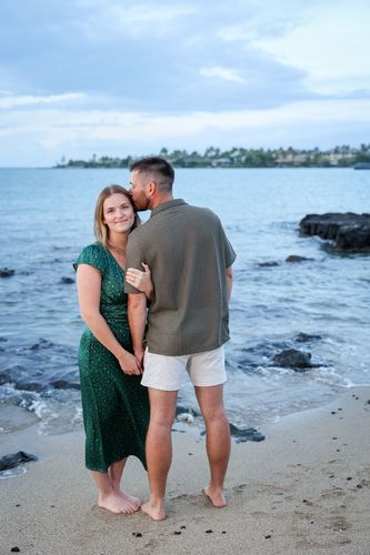A man and woman holding hands on the beach in Hawaii