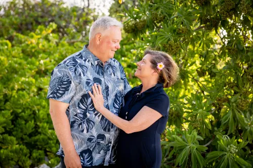 Happy couple celebrating vow renewal in lush tropical garden in Hawaii