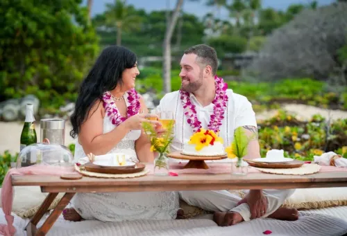 Beach wedding with pink leis and tropical flowers in Hawaii
