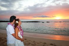 Romantic couple on Hawaii beach during vibrant orange and pink sunset